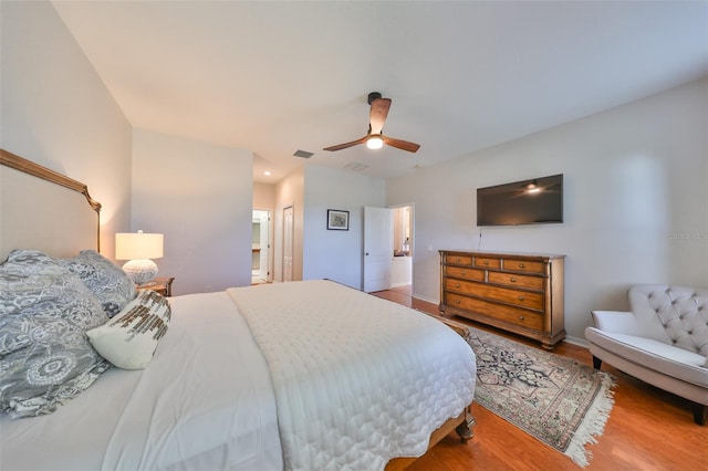 bedroom featuring a closet, ensuite bath, wood-type flooring, and ceiling fan