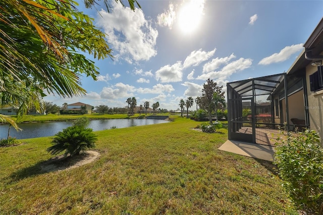 view of yard with a water view and glass enclosure