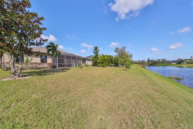 view of yard with a water view and a lanai