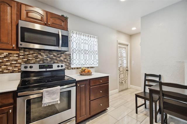 kitchen with stainless steel appliances and backsplash