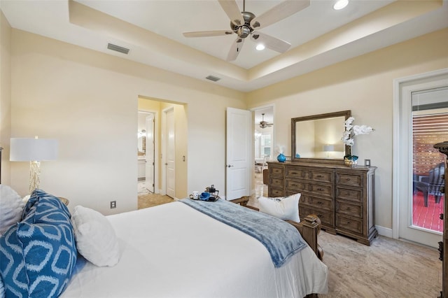 bedroom with a raised ceiling, ensuite bathroom, and ceiling fan