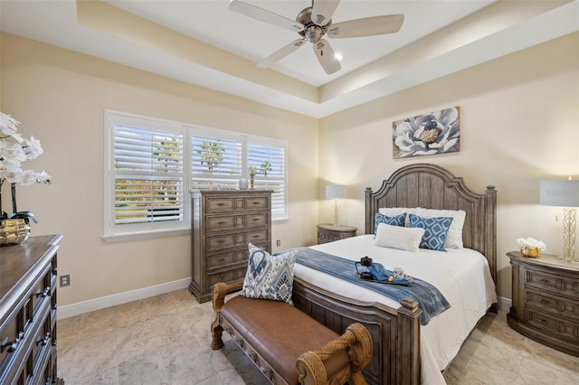 bedroom featuring a raised ceiling and ceiling fan