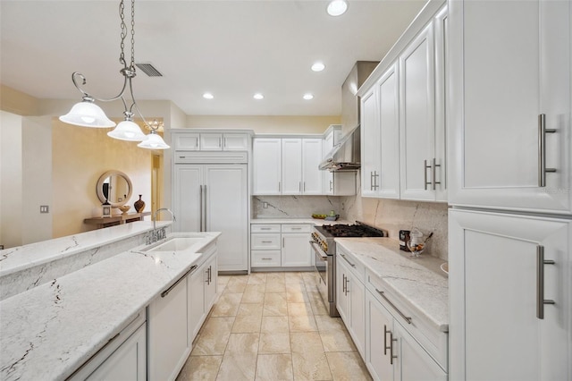 kitchen featuring white cabinets, sink, high quality appliances, and decorative light fixtures