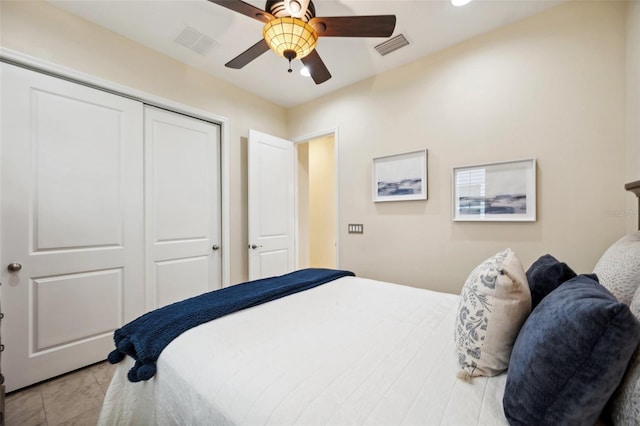 tiled bedroom with ceiling fan and a closet