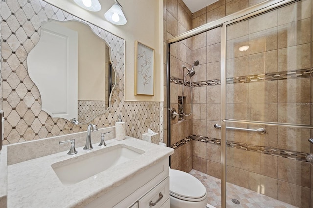 bathroom featuring vanity, an enclosed shower, and toilet