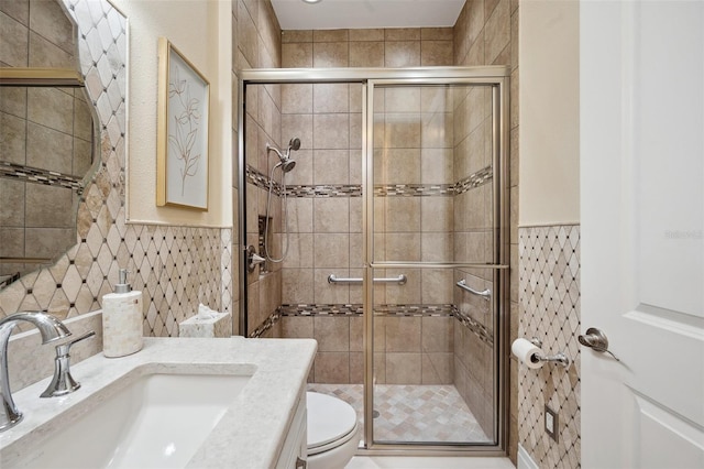 bathroom with tile walls, toilet, vanity, and walk in shower