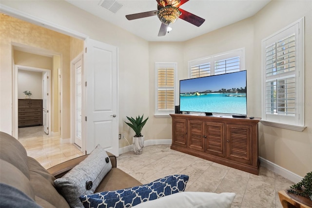 living room featuring ceiling fan and a wealth of natural light