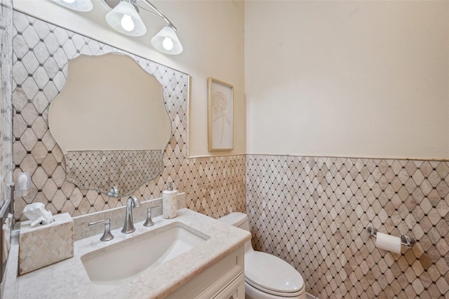 bathroom with vanity, tile walls, and toilet