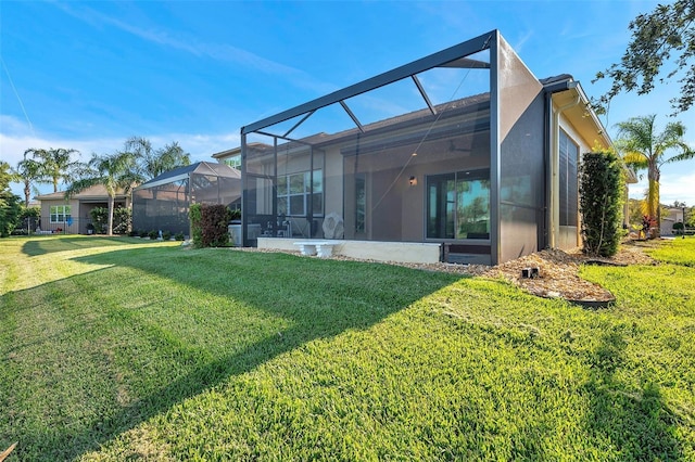 rear view of house with a yard and a lanai