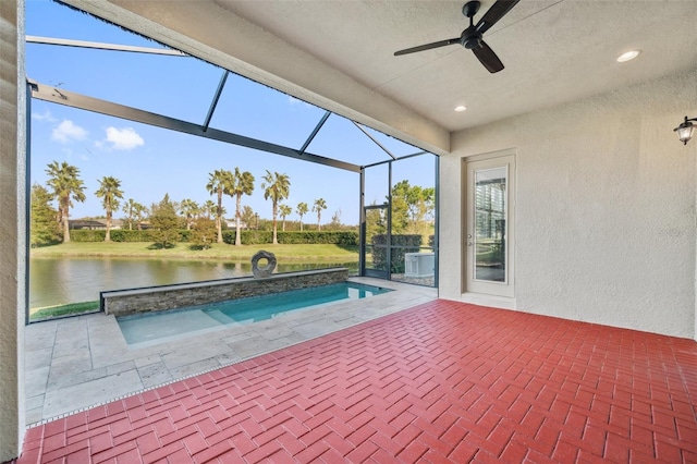 view of swimming pool with a lanai, a water view, ceiling fan, and a patio area