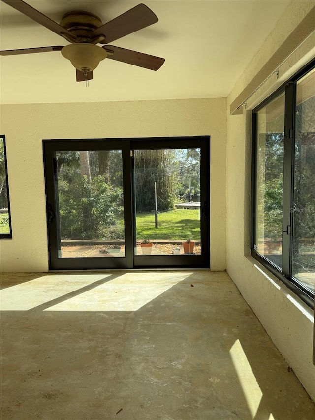 unfurnished sunroom featuring ceiling fan