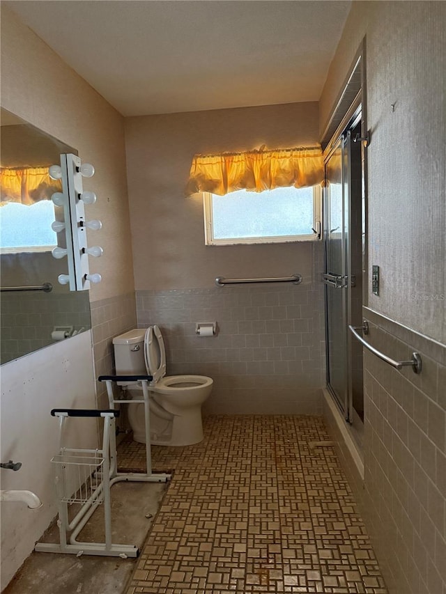 bathroom with tile walls, toilet, and walk in shower