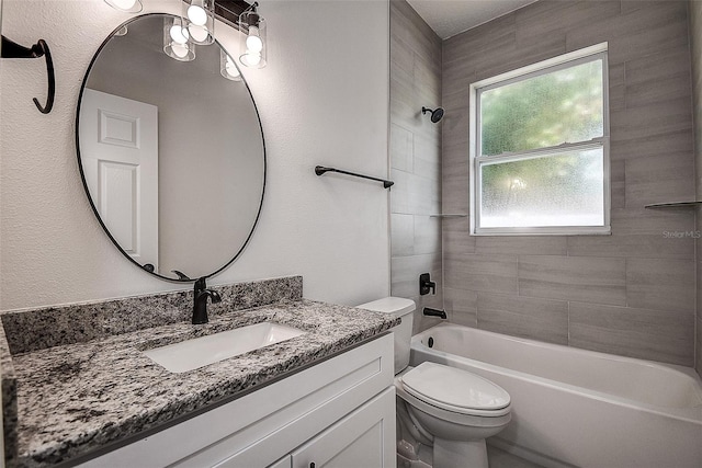 full bathroom with tiled shower / bath, vanity, and toilet