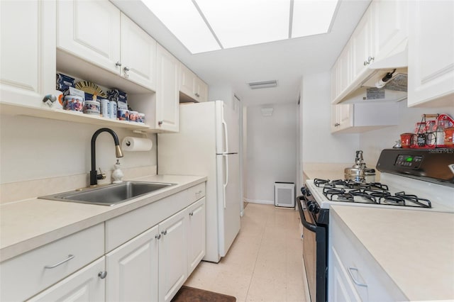 kitchen with sink, white cabinets, and white appliances