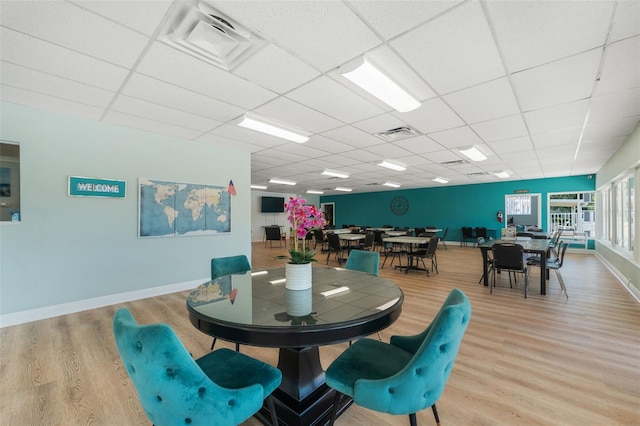 dining area featuring light hardwood / wood-style floors and a paneled ceiling