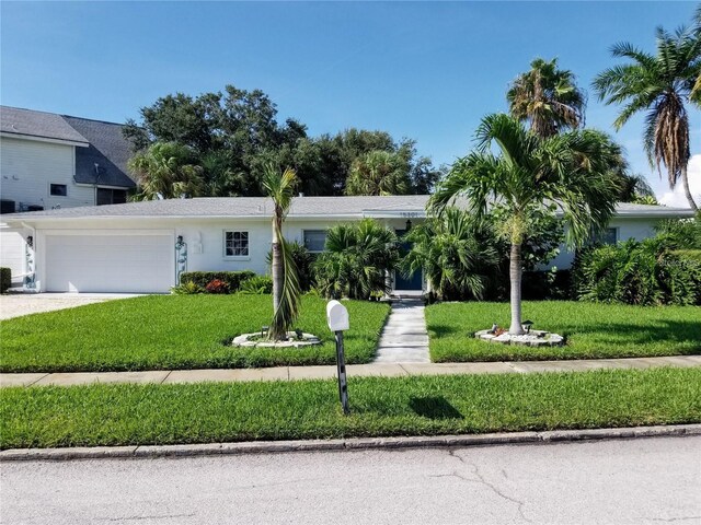 view of front of house with a garage, stucco siding, driveway, and a front yard