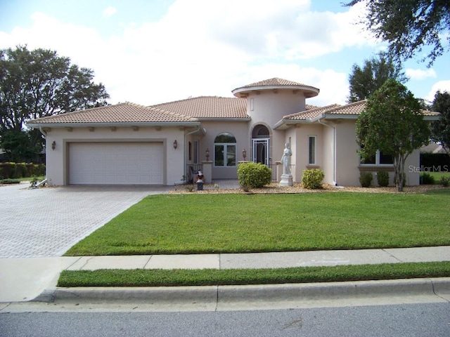 mediterranean / spanish house featuring a front lawn and a garage