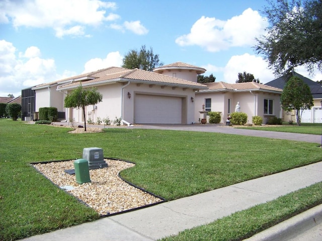 mediterranean / spanish home with a garage and a front lawn