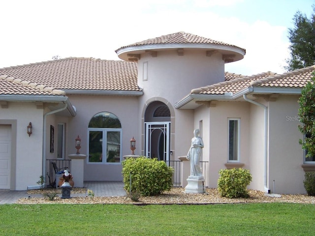 back of property featuring a garage and a lawn