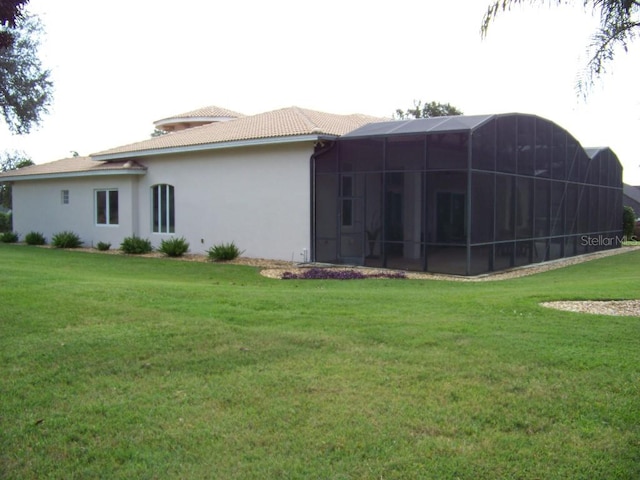 back of property featuring a sunroom and a lawn