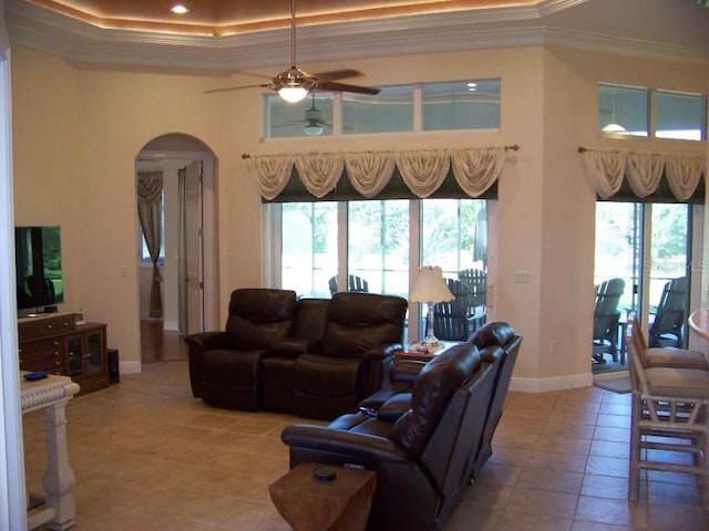 living room featuring crown molding, tile patterned flooring, ceiling fan, and a wealth of natural light