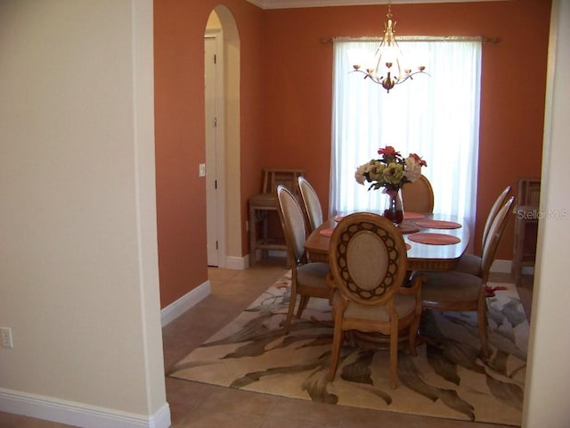 tiled dining room with a notable chandelier