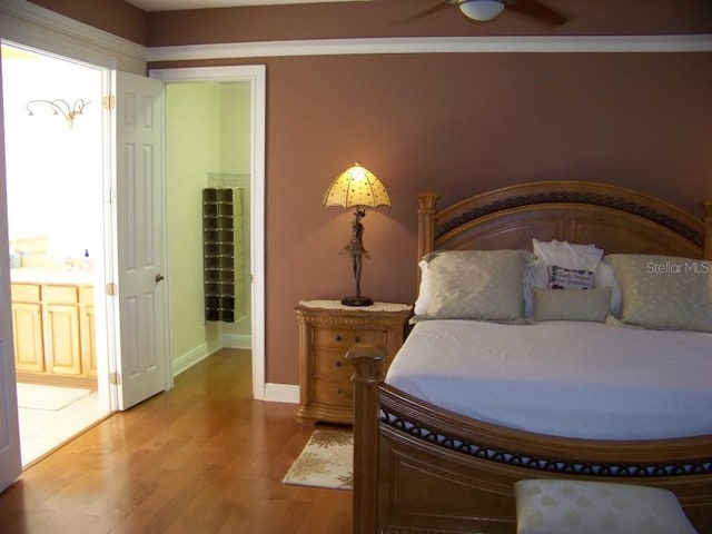 bedroom with connected bathroom, crown molding, wood-type flooring, and ceiling fan