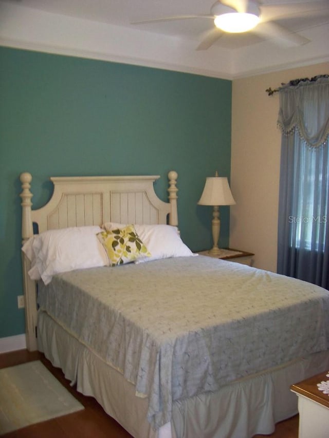 bedroom with dark hardwood / wood-style floors and ceiling fan