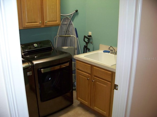 washroom featuring cabinets, sink, and washing machine and dryer