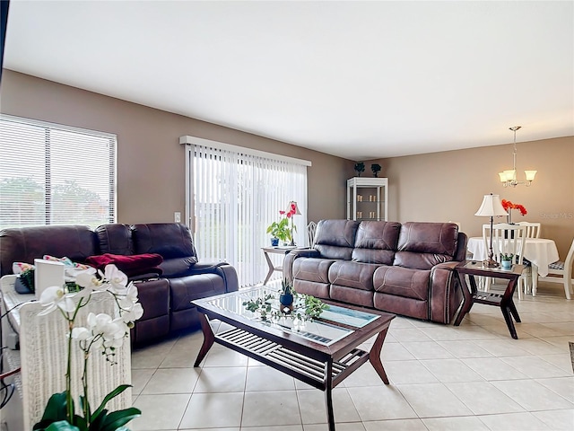 living room with a wealth of natural light, light tile patterned floors, and an inviting chandelier