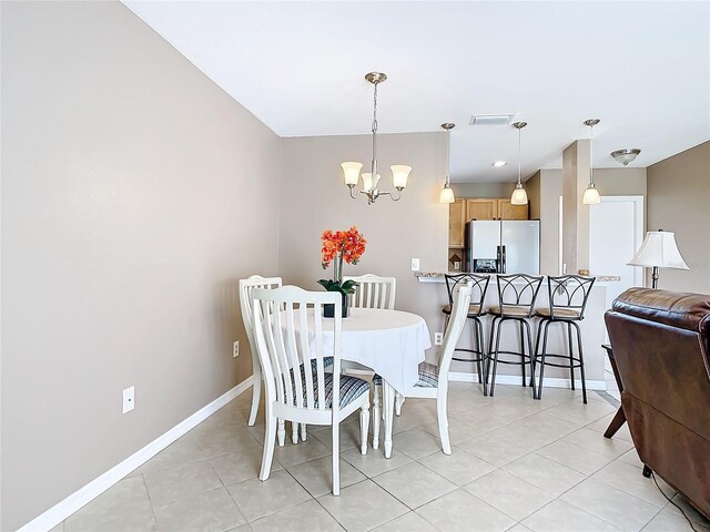 dining space with a chandelier and light tile patterned floors