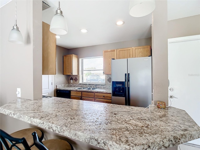 kitchen featuring stainless steel refrigerator with ice dispenser, kitchen peninsula, sink, a kitchen breakfast bar, and decorative light fixtures