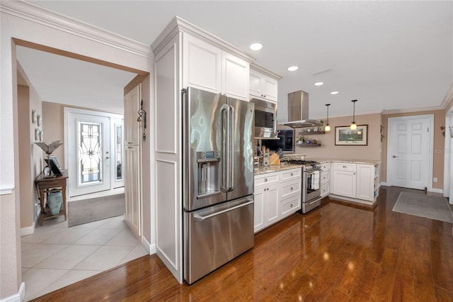 kitchen with island exhaust hood, high quality appliances, hardwood / wood-style floors, decorative light fixtures, and white cabinetry