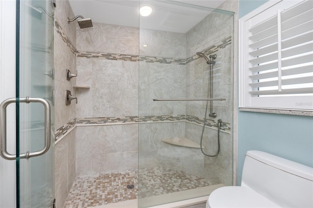 bathroom featuring toilet and an enclosed shower