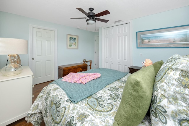 bedroom with dark hardwood / wood-style flooring, a closet, and ceiling fan