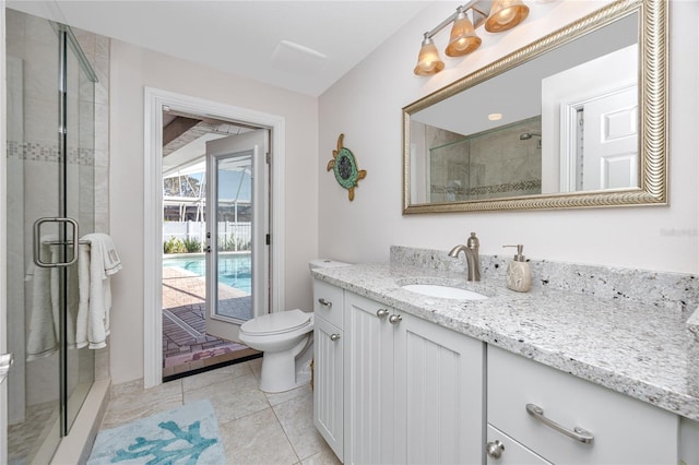 bathroom featuring a shower with door, vanity, toilet, and tile patterned floors