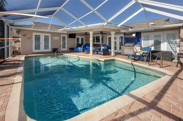 view of pool with french doors, ceiling fan, glass enclosure, and a patio