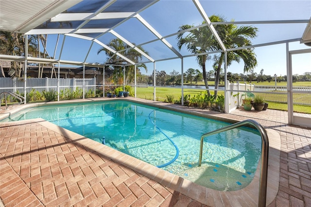 view of pool with a patio, a lanai, a water view, and a yard