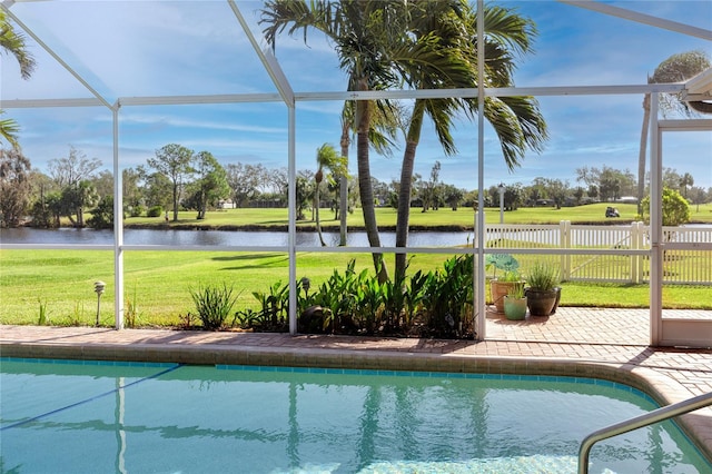 view of pool with a water view, a patio area, glass enclosure, and a yard