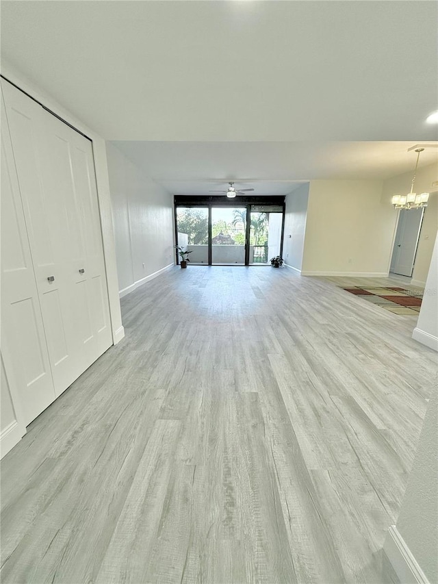 unfurnished living room with light hardwood / wood-style floors and ceiling fan with notable chandelier