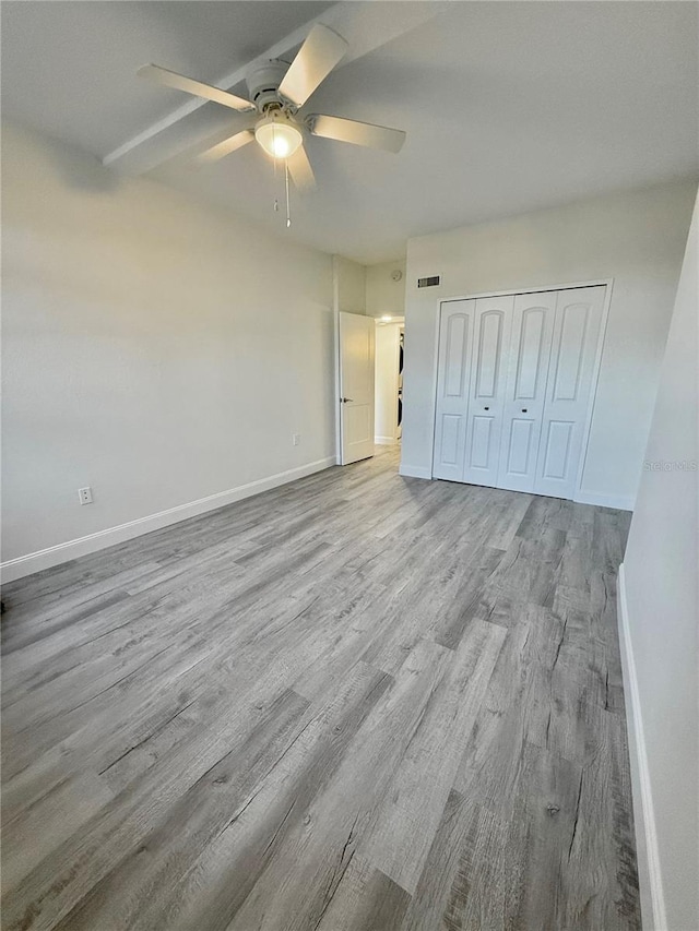 unfurnished bedroom featuring a closet, light wood-type flooring, and ceiling fan