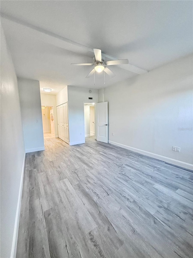 empty room with light wood-type flooring and ceiling fan