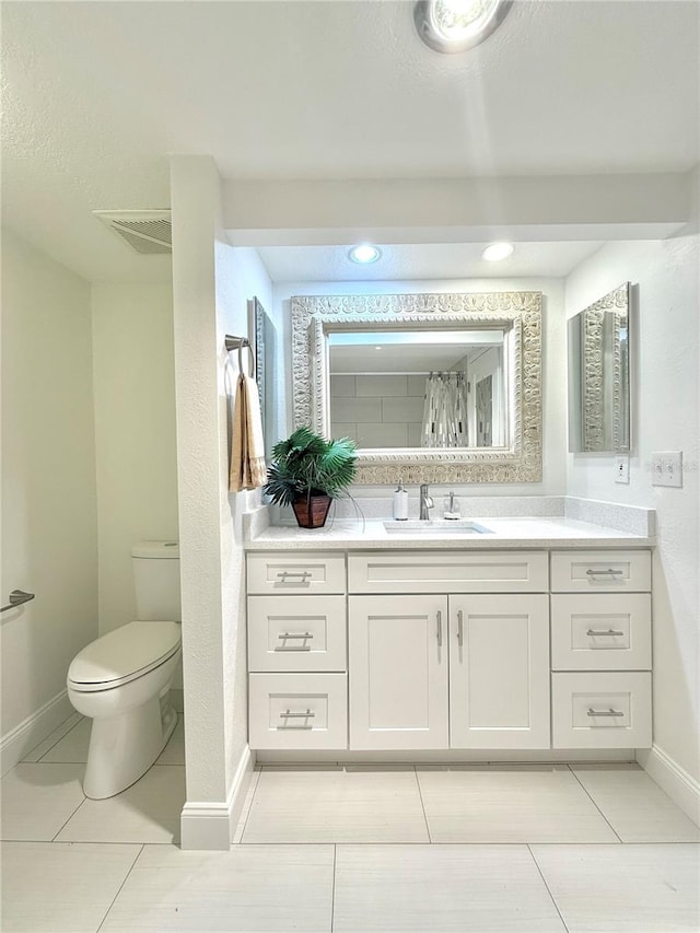 bathroom featuring vanity, toilet, and tile patterned flooring