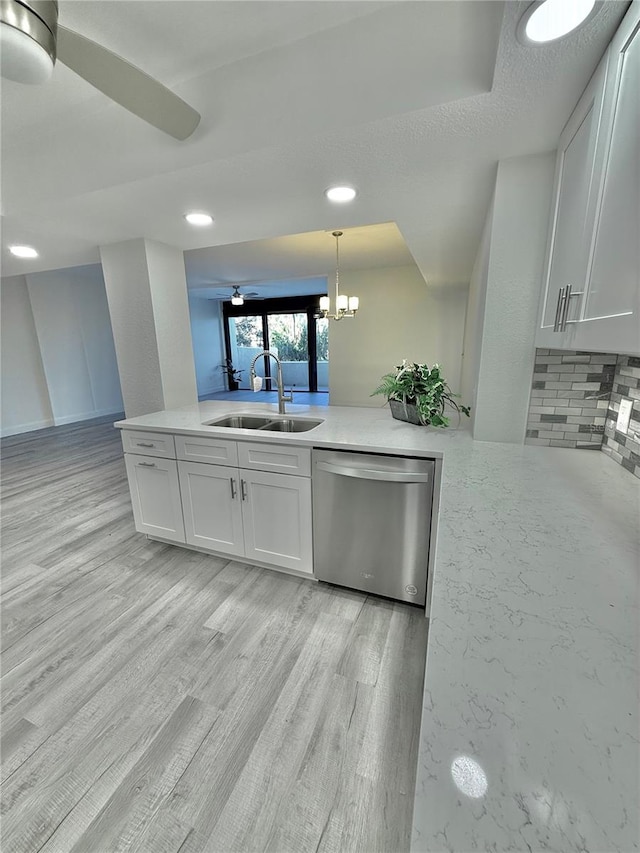 kitchen featuring dishwasher, hanging light fixtures, sink, light wood-type flooring, and white cabinets