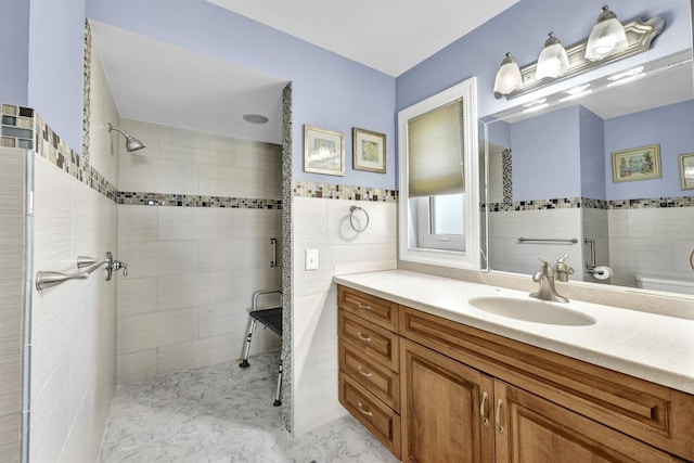 bathroom featuring vanity, tile walls, and tiled shower