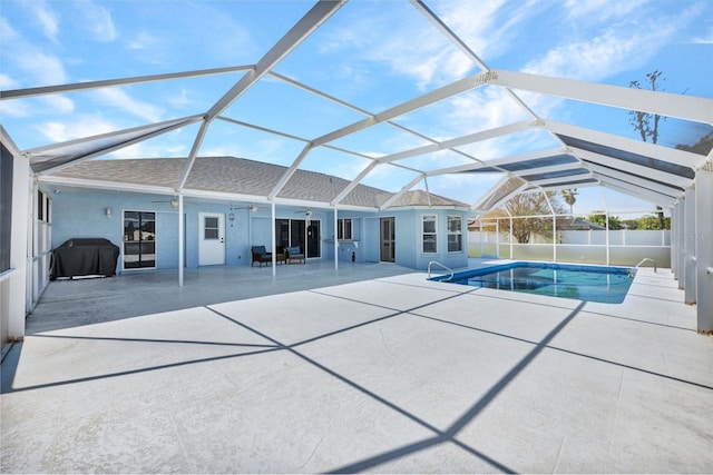 view of swimming pool with a patio, glass enclosure, and a grill