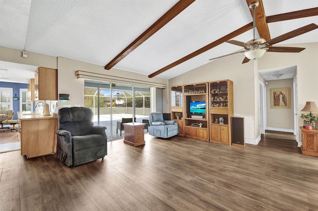 living room with ceiling fan, lofted ceiling with beams, a textured ceiling, and dark hardwood / wood-style floors