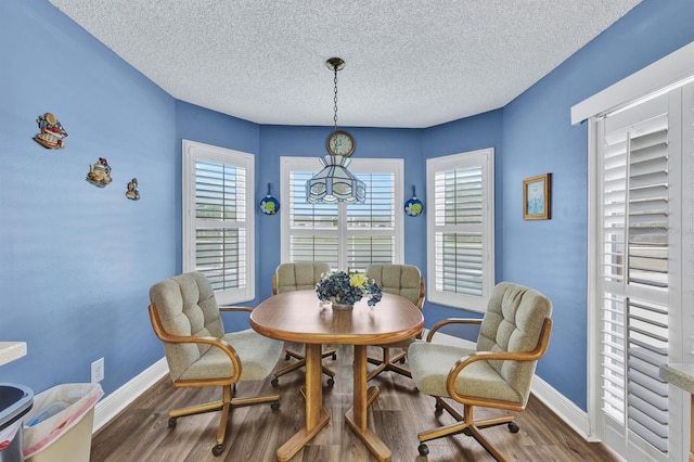 dining space with a textured ceiling and dark hardwood / wood-style flooring