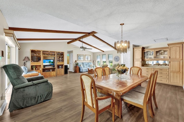 dining area with ceiling fan with notable chandelier, a textured ceiling, vaulted ceiling with beams, and dark hardwood / wood-style floors