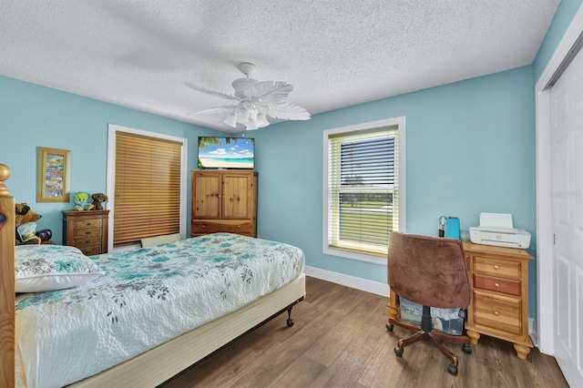 bedroom featuring hardwood / wood-style floors, a textured ceiling, a closet, and ceiling fan